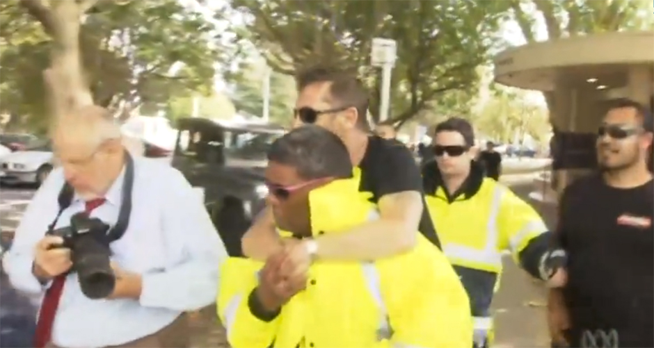 Phil Rudd lässt sich von seinem Wachmann zu seinem Auto tragen