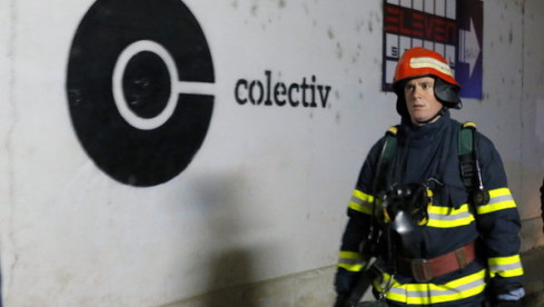 epa05004144 A Romanian fireworker walks past the logo of a club, the site of a fire , in Bucharest, Romania, early 31 Octo...