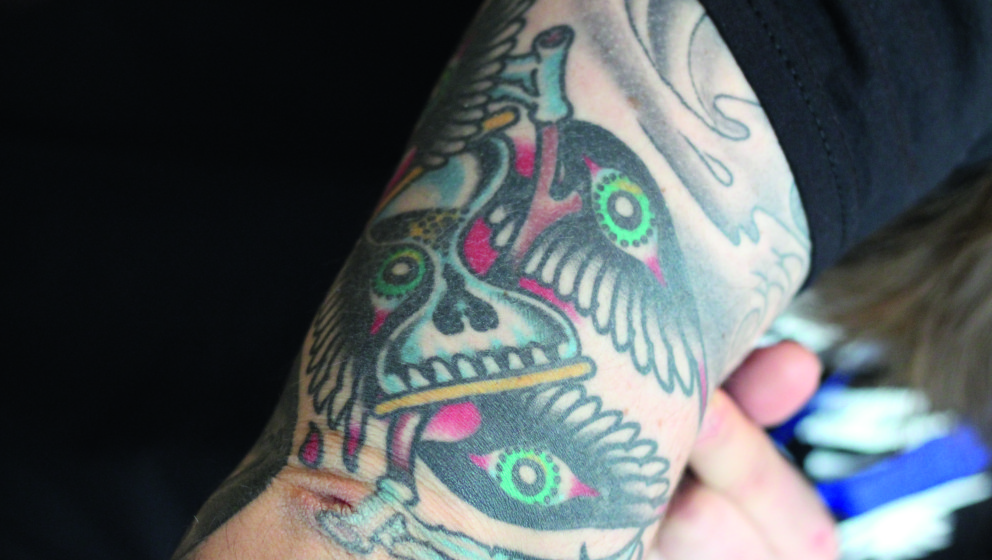 Den Mittelpunkt des Tattoos bilden zwei Sensen und einen Sanduhr. Wie bei den meisten Tattoos des Kvelertak-Sängers hat auch