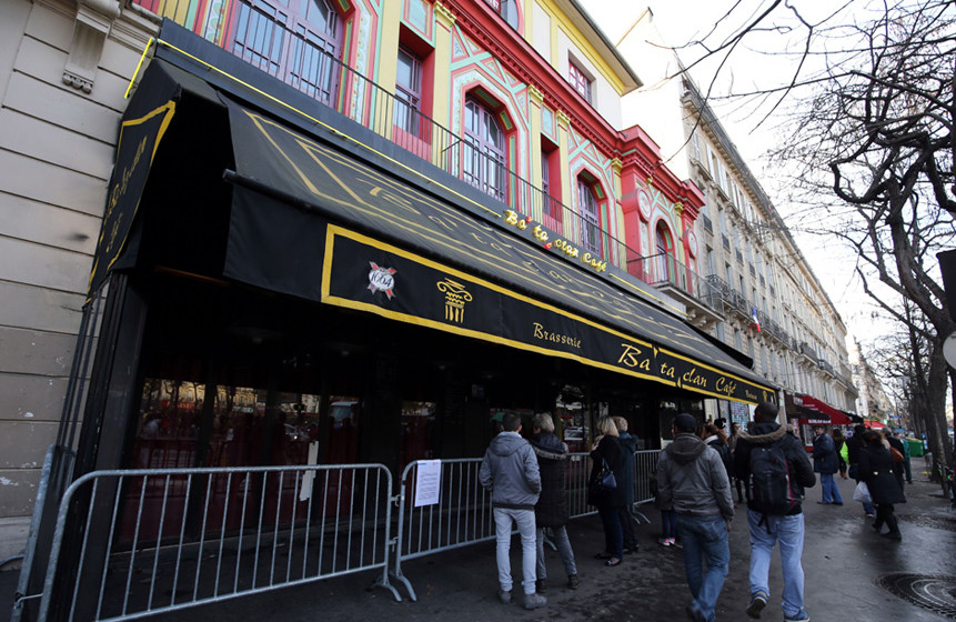 People stand in front of the Bataclan concert hall in Paris on December 22, 2015, after the sidewalk in front of the venue wa