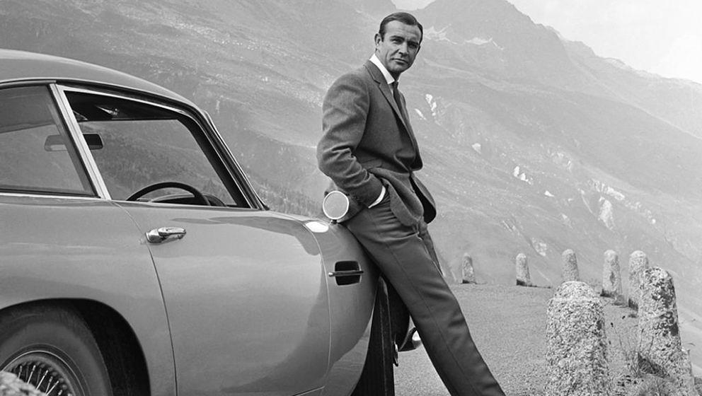 1964:  Actor Sean Connery poses as James Bond next to his Aston Martin DB5 in a scene from the United Artists release 'Goldfi