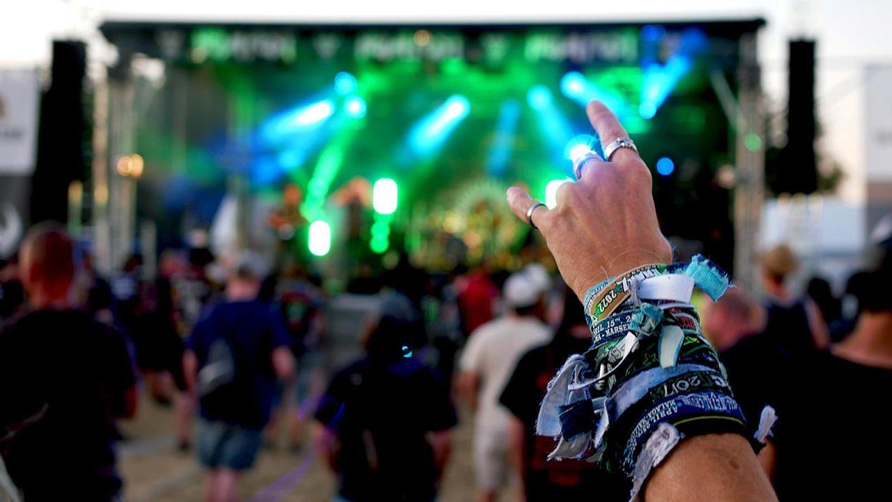 Ein Arm, der sich sichtbar schon auf vielen Festivals erhoben hat, formt die Pommesgabel.