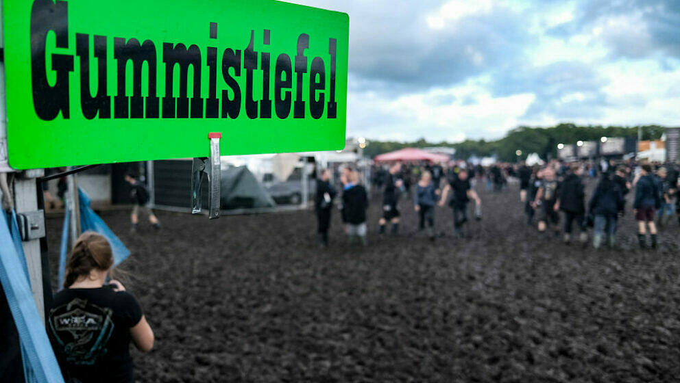 A sign for rubber boots is on diplay as visitors of the Wacken Open Air are fighting against the mud on the festival ground o