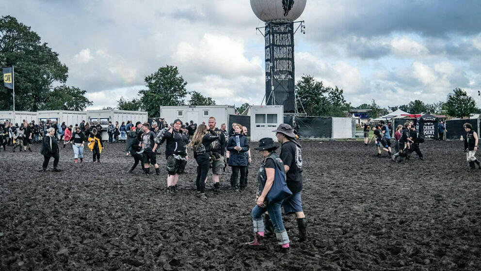 Visitors of the Wacken Open Air are fighting against the mud on the festival ground on August 1, 2023. Wacken Open Air, one o